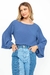 Mulher usando calça jeans mix e blusa azul com mangas largas.