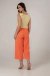 Mulher de perfil usando a Calça Clochard Cargo Laranja Rubinella com blusa leve, em um look casual e moderno.