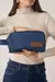 Necessaire Andreza Chagas em tecido jeans azul sendo segurada pela modelo, ideal para organizar acessórios e itens pessoais.