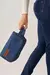 Necessaire Andreza Chagas azul em tecido jeans, sendo carregada por uma modelo vestindo a nossa calça jeans skinny Power.