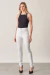 Calça Skinny branca de cintura alta e cós triplo com os botões de pressão forrados, foto frontal all look.