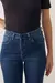foto com foco nos botões forrados da Calça jeans skinny azul médio acetinada
