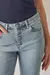 Calça skinny clara de cintura alta e botões forrados, foto frontal com foco nos detalhes dos botões da peça.