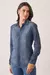 Camisa jeans feminina com detalhes em suede nos punhos e ombros, manga longa, usada por modelo.