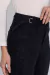 Calça Reta Lis Preto Estonado, foto frontal com foco no detalhe do cós e nas pedrarias aplicadas ao produto.