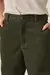 Modelo vestindo calça reta em veludo cotelê verde pesto, vista frontal com blusa clara e salto.