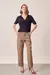Modelo vestindo calça cargo reta avelã de cintura alta, com blusa navy e salto, vista frontal