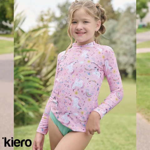 Nena usando camiseta clásica estampada de tricot color rosa con unicornios, modelo 4309-KIM de Kiero, en un entorno al aire libre.