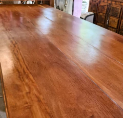 Mesa de jantar com design de pés diamantados, feita em madeira de demolição, com acabamento artesanal e capacidade para oito pessoas.