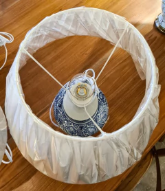 Abajur decorativo em cerâmica branca e azul com detalhes em metal, ideal para iluminação de ambientes sofisticados.