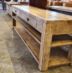 Rack baixo artesanal com duas gavetas e prateleiras, feito em madeira de demolição, proporcionando aconchego à decoração da sala.