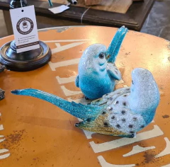 Pássaro decorativo tricolor (azul, marrom e branco) em resina, peça exclusiva da Marcenaria Tiradentes. Ideal para decorações sofisticadas e sustentáveis.