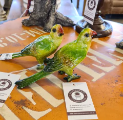 Pássaro artesanal de resina na cor verde com bico vermelho, ideal para decoração sofisticada e sustentável.