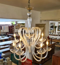 Lustre elegante com 12 braços em cristal e estrutura robusta em ferro, iluminando e valorizando o ambiente.