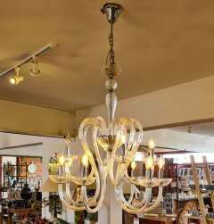 Lustre elegante com 12 braços em cristal e estrutura robusta em ferro, iluminando e valorizando o ambiente.