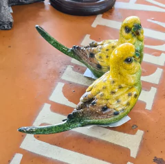 Pássaro artesanal de resina nas cores amarelo e verde, representando a qualidade e exclusividade da Marcenaria Tiradentes.