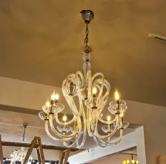 Lustre elegante com 12 braços em cristal e estrutura robusta em ferro, iluminando e valorizando o ambiente.