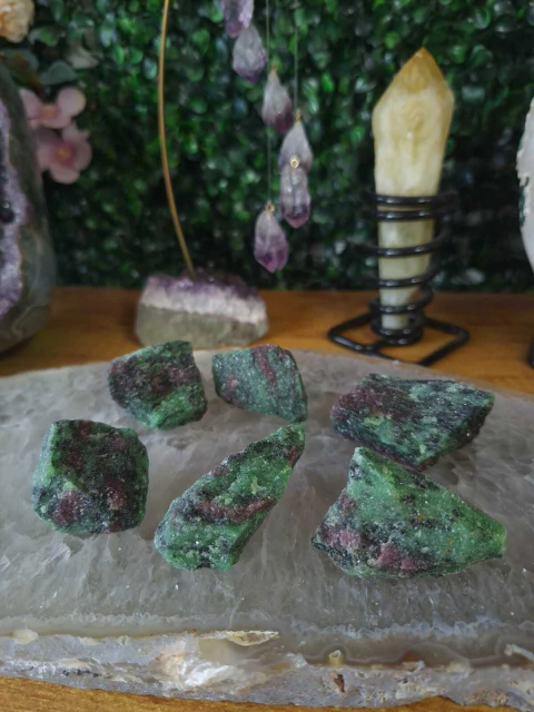 Pedras brutas naturais de zoisita com rubi em tons verde e vermelho sobre base de cristal translúcido