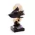 Escultura decorativa em resina representando um rosto com uma mão cobrindo os olhos, nas cores dourado e preto, com base escura.