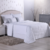 Conjunto de peseira Copacabana 5 peças queen em percal 300 fios, incluindo almofadas cheias, sobre uma cama com lençóis brancos.