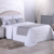 Conjunto de cama com peseira em tom cinza, almofadas e lençóis brancos, decorado em ambiente moderno.