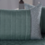 Peseira de cama em tom verde com almofadas cheias em tecido cinza, ideal para decoração de camas queen.