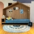 Tapete de algodão em formato redondo com números, decorando um quarto infantil com uma cama azul e elementos decorativos.