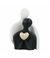 Estatueta de casal de porcelana segurando um coração dourado, simbolizando amor e união, com dimensões de 17.5cm.