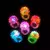 Anillos de silicona con luces de colores en forma de flor, sobre fondo negro.