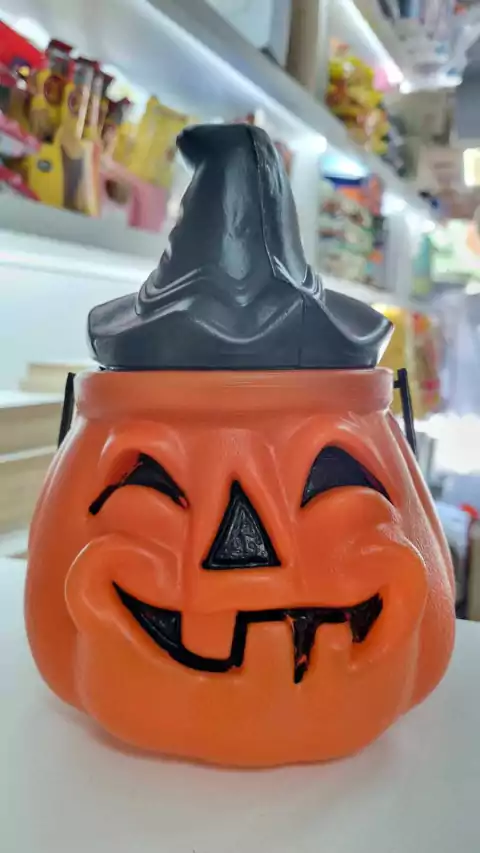 Calabaza arrugada de Halloween con cara sonriente y sombrero de bruja, ideal para decoración festiva.