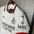 Camisa branca do AC Milan com detalhes em vermelho e preto, exibindo logo da equipe e patrocinadores.