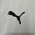 Camisa branca do AC Milan com detalhes em vermelho e preto, exibindo logo da equipe e patrocinadores.
