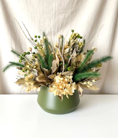 Arranjo seco com flores e folhas em tons naturais dentro de vaso de metal verde