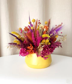 Arranjo de flores secas rosa e amarela em vaso de metal amarelo 