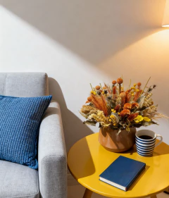 Arranjo seco com flores e folhagens em tons de amarelo, laranja e marrom em vaso de metal marrom