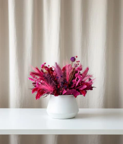 Arranjo seco com flores em tons de rosa e roxo em vaso de metal creme 