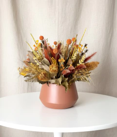 Arranjo seco com flores e folhagens em tons de amarelo, laranja e marrom em vaso de metal marrom