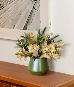 Arranjo seco com flores e folhas em tons naturais dentro de vaso de metal verde