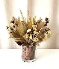 Arranjo de flores secas em vaso de vidro transparente com elementos naturais em tons de marfim e marrom