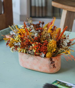 Jardineira com arranjo de flores secas amarelo e laranja
