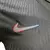 Logo Nike colorido aplicado em camisa preta com textura detalhada