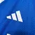 Detalhe da camisa azul do Cruzeiro com o logo da Adidas em destaque.