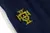 Emblema bordado da Seleção Portuguesa de Futebol em uma calça de um conjunto de treino azul.