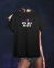 Camisa preta com a frase "Get Him Back!" em destaque, inspirada na artista Olivia Rodrigo.
