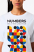 Camiseta branca com estampa colorida que apresenta a frase "NUMBERS RULE THE UNIVERSE" e formas geométricas em vermelho, amarelo, azul e preto.