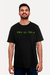 Camiseta preta com a frase "Wake up, Neo..." em verde, modelo masculino sorridente. Loja nerd Chic - Moda Geek para mentes brilhantes