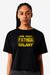 Camiseta preta com estampa escrita "The Best Father in the Galaxy" em letras amarelas, modelo feminino.