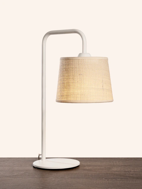 Lámpara de mesa HANG con pantalla chica de arpillera color beige y base metálica blanca sobre mesa de madera
