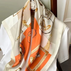 Lenço feminino estampado em poliéster com tons de creme, laranja e detalhes dourados, usado sobre camisa branca