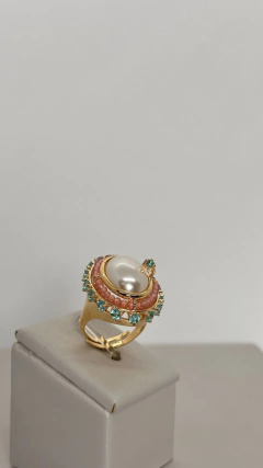 Anel ajustável com banho em ouro amarelo 18k, com design arredondado, pérola central e mix de cristais rosa e azul